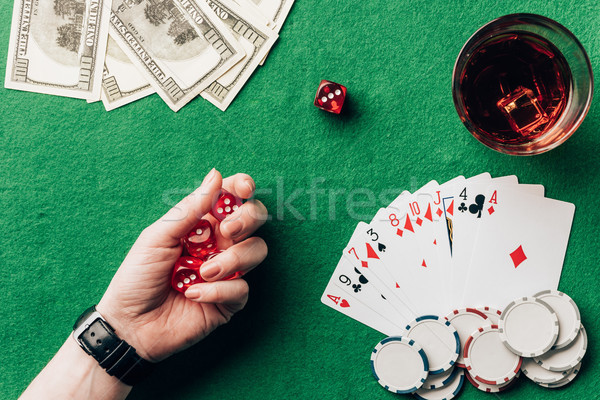 Woman holding dice by casino table with money and chips Stock photo © LightFieldStudios