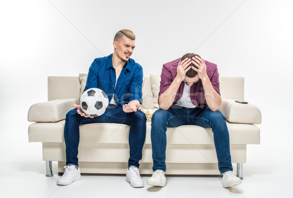 Stock photo: Friends sitting on couch with soccer ball  