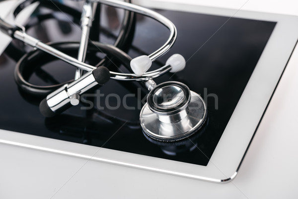 close up view of reflex hammer and stethoscope on digital tablet on white Stock photo © LightFieldStudios