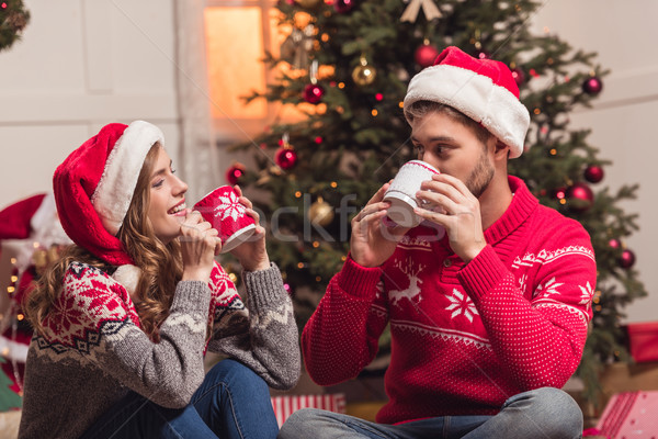 couple with cups at christmastime Stock photo © LightFieldStudios