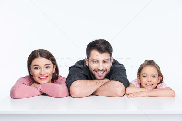 Happy young family with one child looking at camera on white   Stock photo © LightFieldStudios