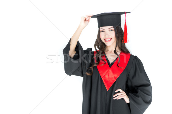 Beautiful young brunette woman adjusting mortarboard and smiling at camera   Stock photo © LightFieldStudios