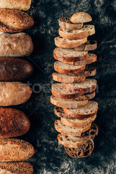 top view of arranged loafs and pieces of bread on dark tabletop Stock photo © LightFieldStudios