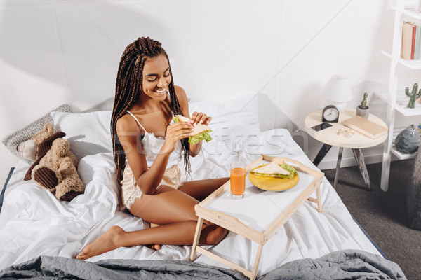 woman eating breakfast in bed Stock photo © LightFieldStudios
