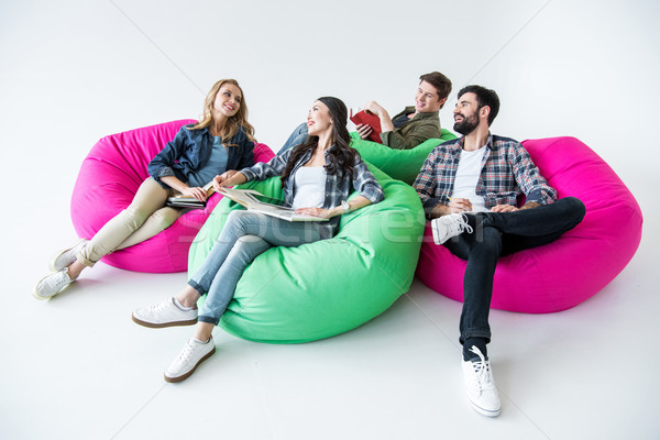 students sitting on beanbag chairs and studying in studio on white  Stock photo © LightFieldStudios