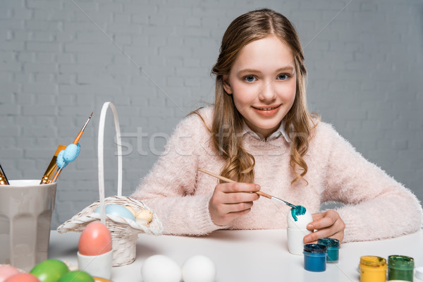dorable happy girl painting easter egg and smiling at camera Stock photo © LightFieldStudios