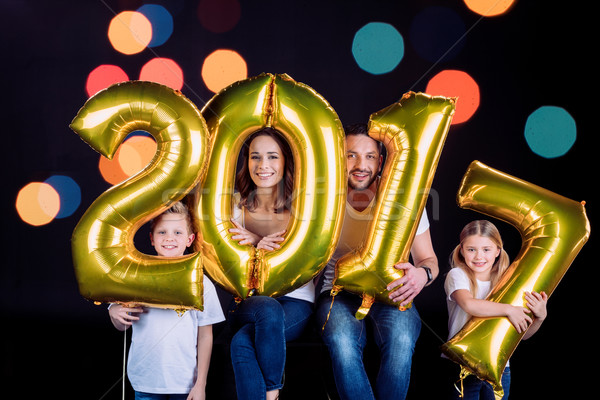 Happy family holding golden balloons  Stock photo © LightFieldStudios