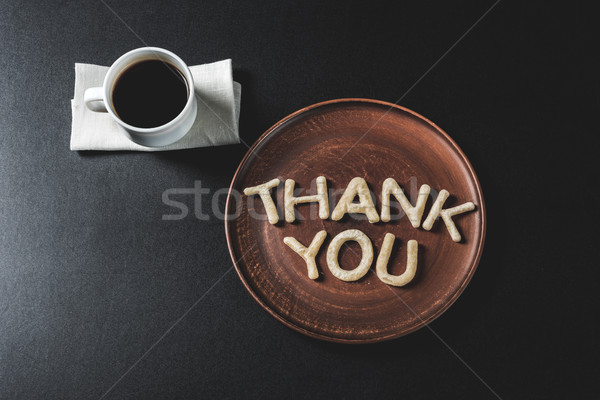 Stock photo: top view of lettering thank you made from cookie dough on wooden plate with coffee cup