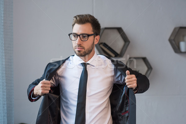 businessman putting on blazer Stock photo © LightFieldStudios