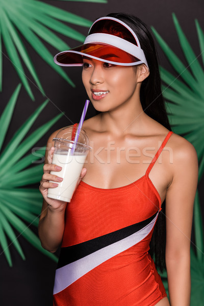 woman in swimsuit and visor drinking milkshake Stock photo © LightFieldStudios