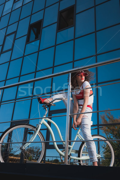 Elegáns nő bicikli sapka farmer ül Stock fotó © LightFieldStudios
