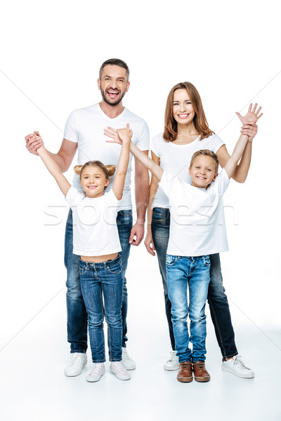 Família feliz as mãos levantadas branco jeans em pé olhando Foto stock © LightFieldStudios