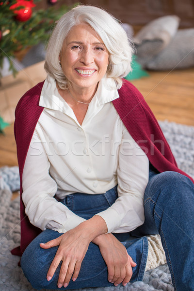 Senior vrouw vergadering vloer glimlachend naar Stockfoto © LightFieldStudios