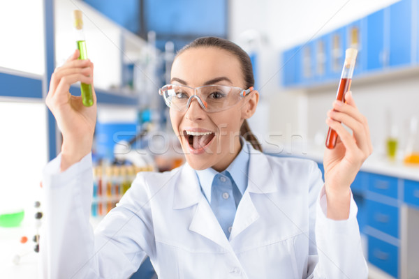 portrait of cheerful scientist showing laboratory tubes and looking to camera Stock photo © LightFieldStudios