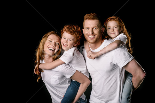 Happy redhead family in white t-shirts smiling isolated on black Stock photo © LightFieldStudios