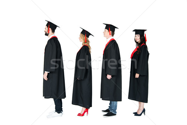 Full length side view of students in academic caps and graduation gowns standing in a row Stock photo © LightFieldStudios