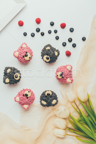 top view of delicious fruity muffins in shape of bears and beautiful tulips Stock photo © LightFieldStudios