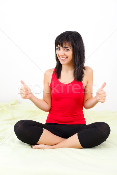 Stock photo: Smiling girl showing thumbs-up cheerfully