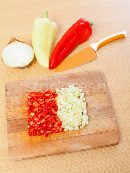 Peaces of paprika, whole pepper and half cut onion  next to a knife. Stock photo © Lighthunter