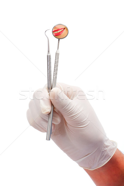 A dentists hands with rubber protective gloves holding dental tools : a probe and an oral mirror - i Stock photo © Lighthunter