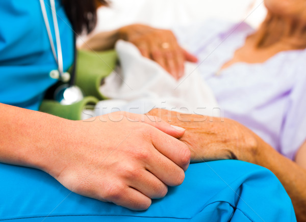 Gondoskodó nővér kéz a kézben tart idős kezek Stock fotó © Lighthunter