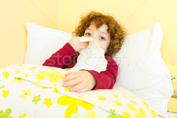 Sick child in bed blowing her nose Stock photo © Lighthunter