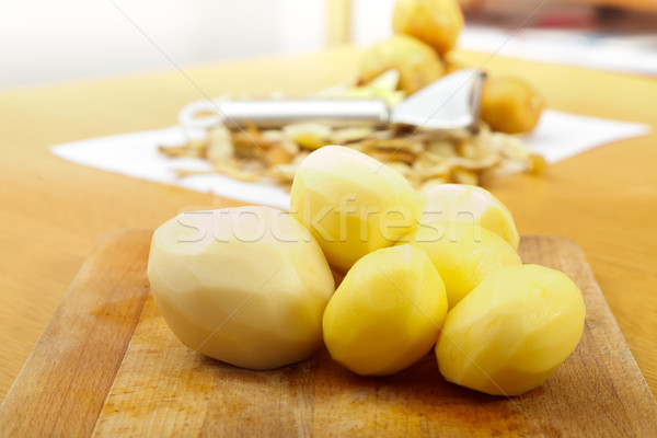 Peeled potatoes on wooden plate Stock photo © Lighthunter