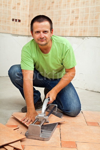 Man Cutting Ceramic Floor Tiles With Manual Cutter Stock Photo