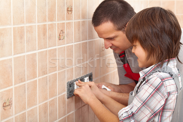 Stock photo: Electrician father teaching son how to install electrical socket