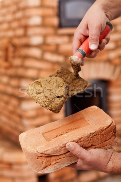 Masonry heater builder hand with brick and trowel Stock photo © lightkeeper