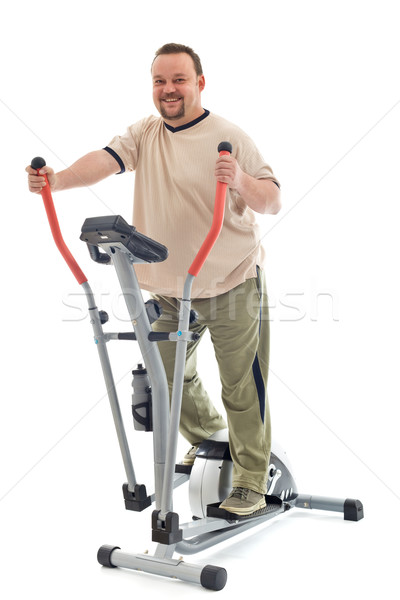 Man exercising on elliptical trainer Stock photo © lightkeeper