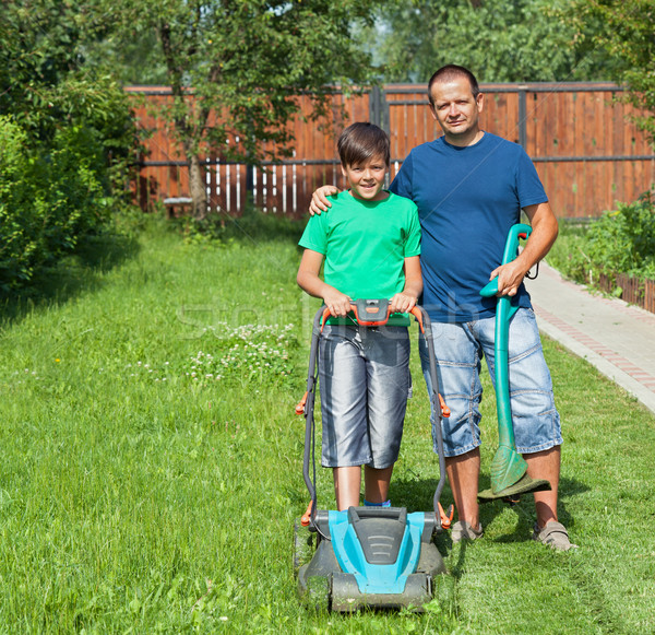 Father and son mowing the lawn and trimming the edges together Stock photo © lightkeeper