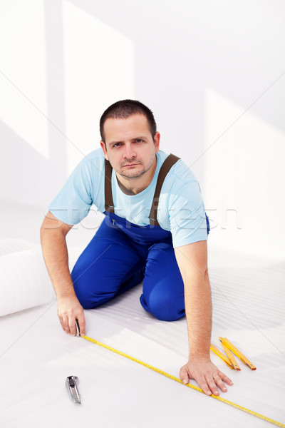 Home improvement - man laying isolating foam layer Stock photo © lightkeeper