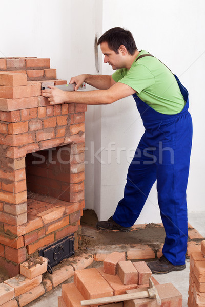Worker building brick stove or fireplace Stock photo © lightkeeper