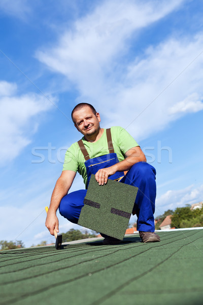 Worker installs bitumen roof shingles Stock photo © lightkeeper