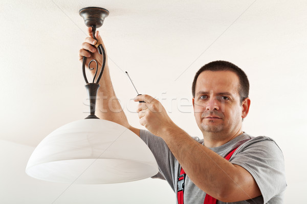 Electrician mounting ceiling lamp Stock photo © lightkeeper