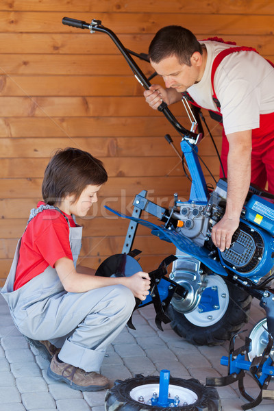 Boy helps his father mounting a cultivator machine Stock photo © lightkeeper