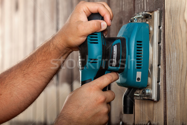 Male hands using a vibrating sander on wooden surface Stock photo © lightkeeper
