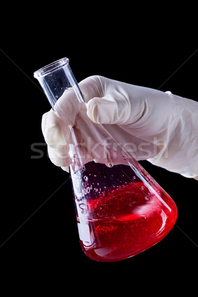 Hand stirring and shaking red liquid in Erlenmayer flask Stock photo © lightkeeper