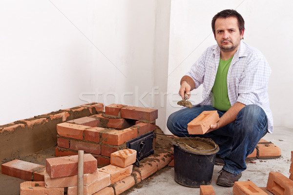 Man building a brick stove or fireplace Stock photo © lightkeeper