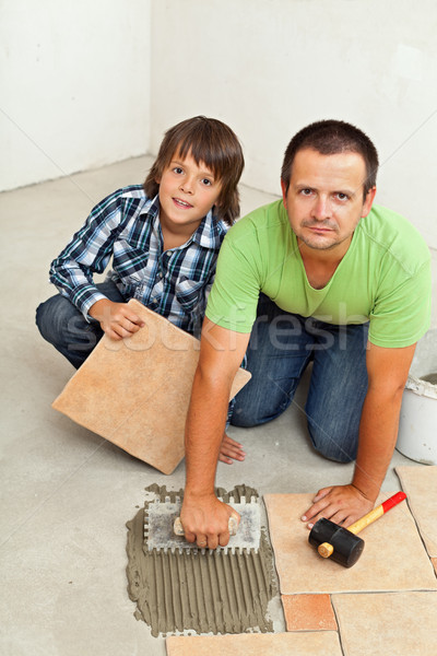 Father and son mounting ceramic floor tiles together Stock photo © lightkeeper