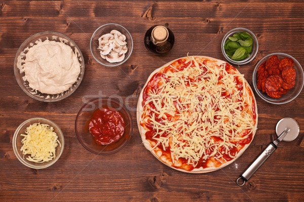 Phases of making a pizza - putting on the grated cheese Stock photo © lightkeeper