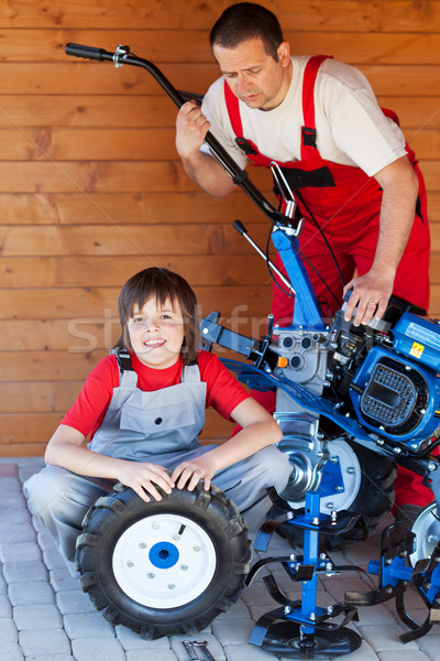 Man and boy servicing a cultivator machine Stock photo © lightkeeper