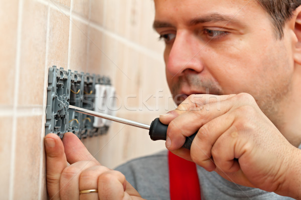 Electrician mounting electrical wall fixture Stock photo © lightkeeper