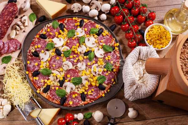 Home made pizza with ingredients on the table - top view Stock photo © lightkeeper