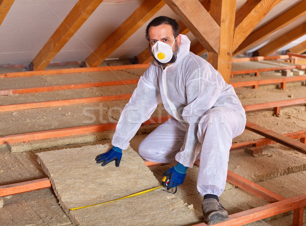 Stock photo: Man laying thermal insulation