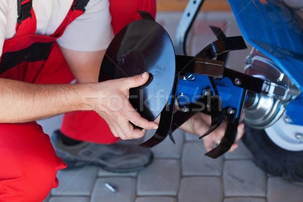 Worker mounting tilling accessory on a cultivator machine Stock photo © lightkeeper