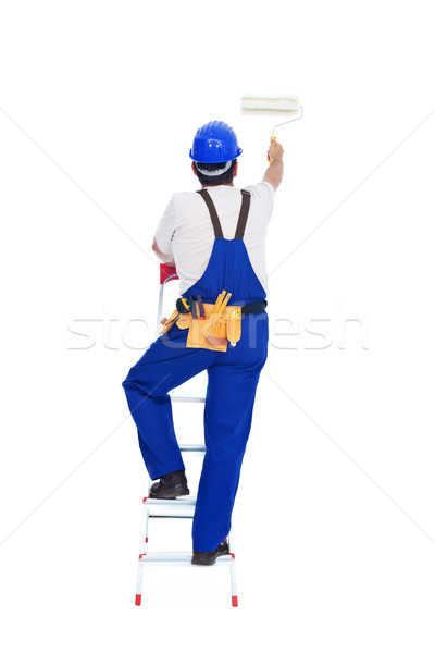 Stock photo: Handyman or worker painting with roller brush on a ladder