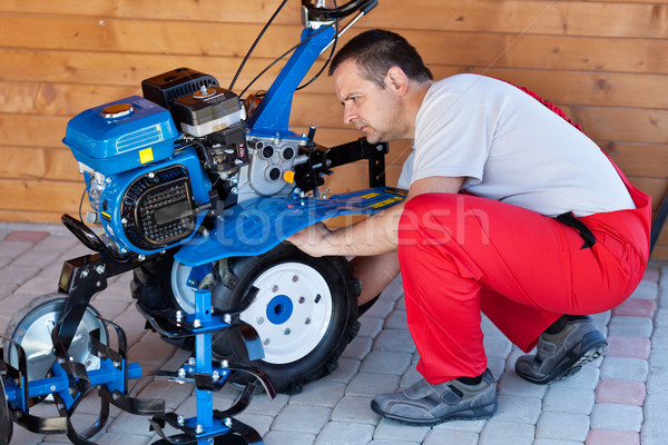 Stock photo: Small scale agriculture - man checking on small motorized tiller