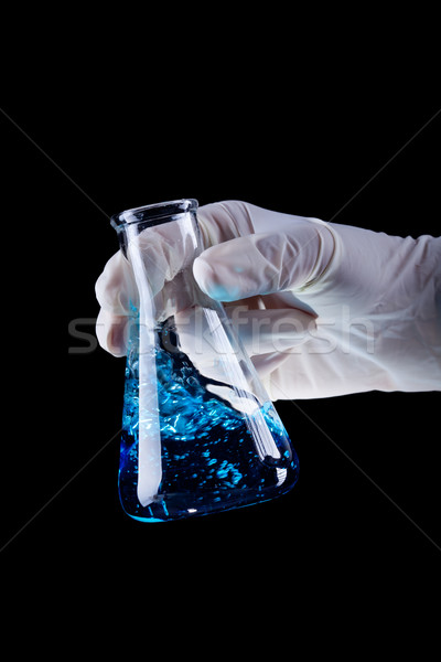Hand holding chemical flask stirring blue liquid Stock photo © lightkeeper